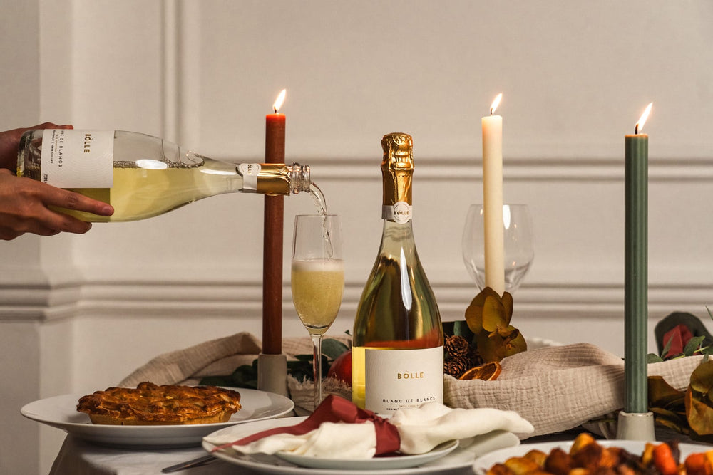 BOLLE Blanc de Blancs poured into a flute on a candlelit Thanksgiving table
