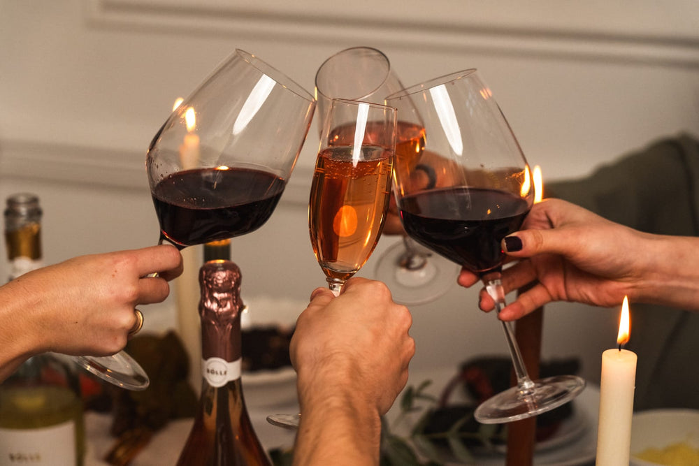 Glasses of BOLLE Cabernet and Rosé raised in a toast, a bottle of Rosé on the table