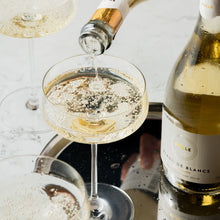 Pouring BOLLE Blanc de Blancs non-alcoholic sparkling wine into coupe glass, best alcohol-free champagne with bubbles